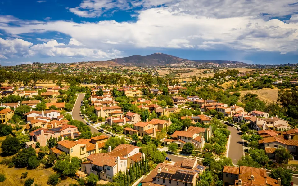 A quiet San Diego neighborhood with open hills and mountain views, reflecting the calmer environment Summit Push is built around.